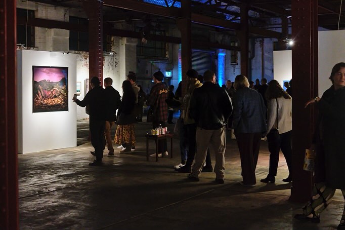 Visitors exploring the moody and industrial interior of the Perth Centre for Photography in Fremantle