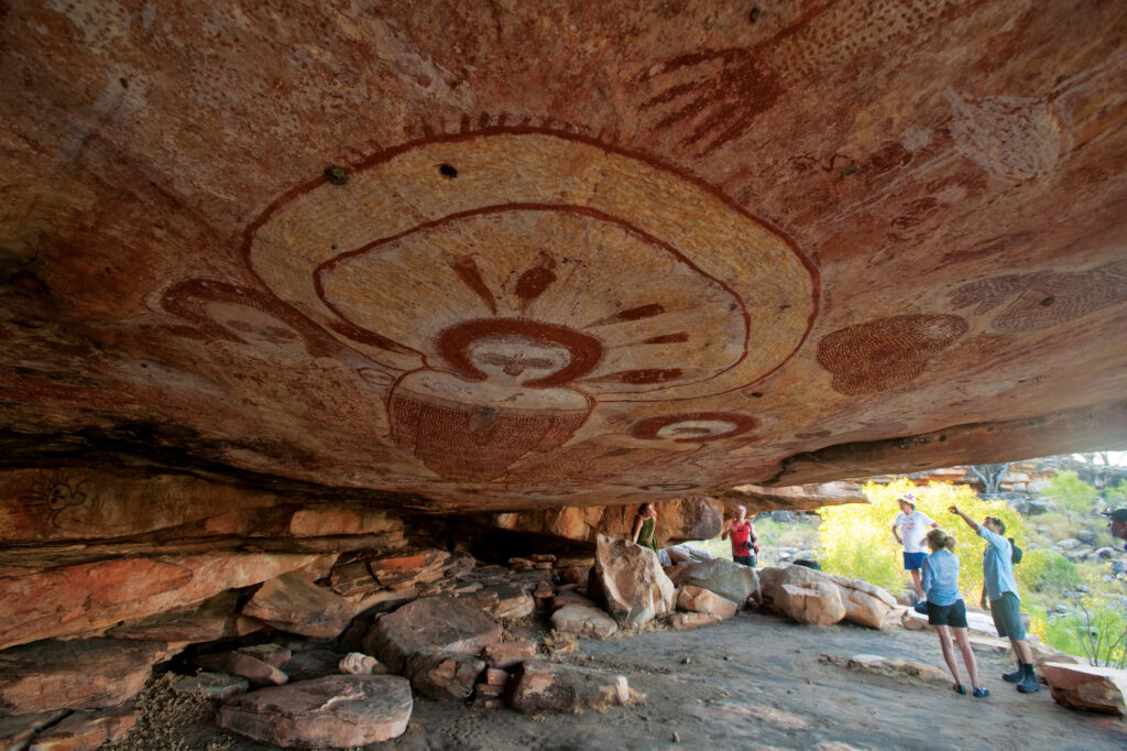 Tourists exploring ancient Aboriginal rock art in the Kimberley